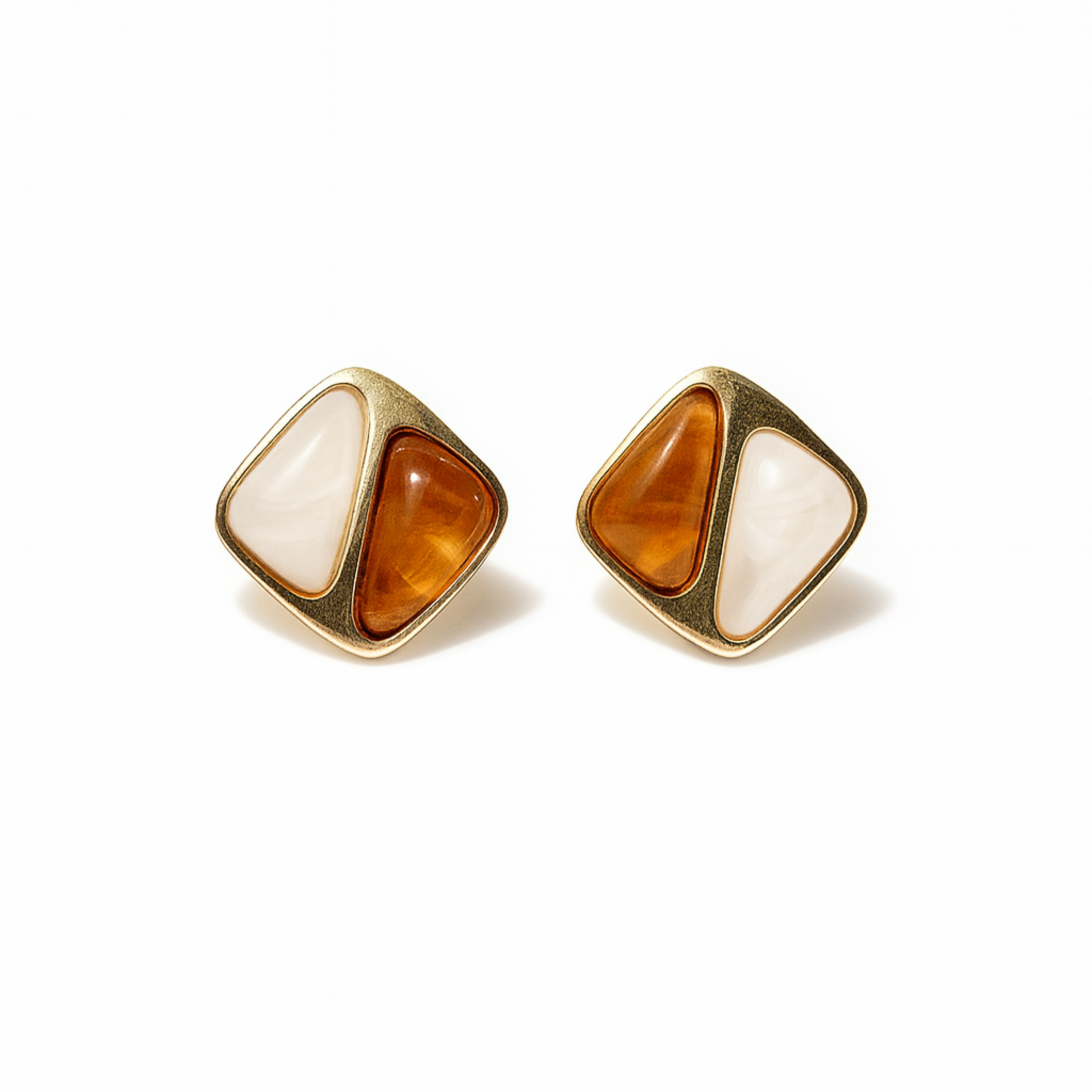 Pair of gold earrings with orange and white stones on a white background