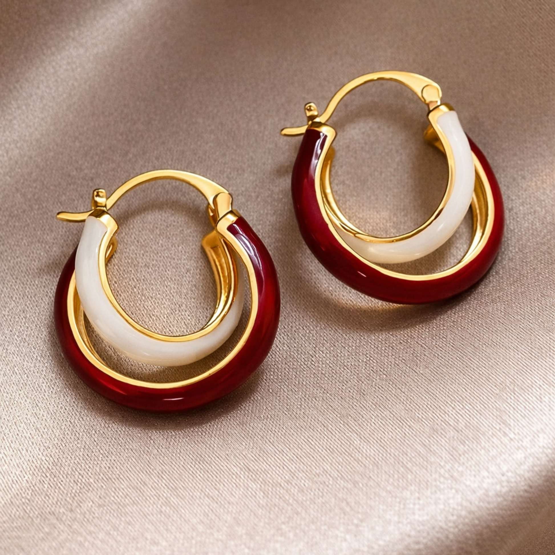 Pair of gold hoop earrings with red and white circular accents 