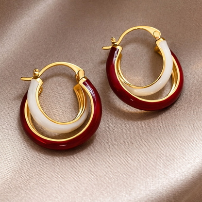 Pair of gold hoop earrings with red and white circular accents 